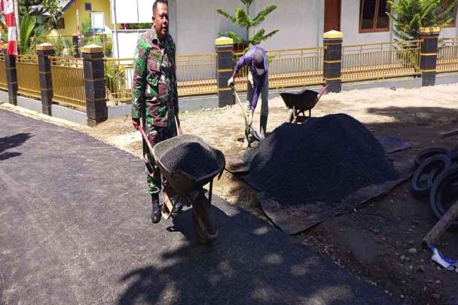 Berikan Semangat Babinsa Membantu Pengaspalan Jalan di Permukiman Warga