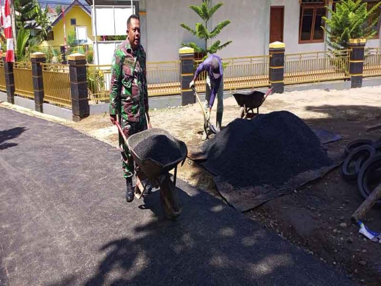 Berikan Semangat Babinsa Membantu Pengaspalan Jalan di Permukiman Warga