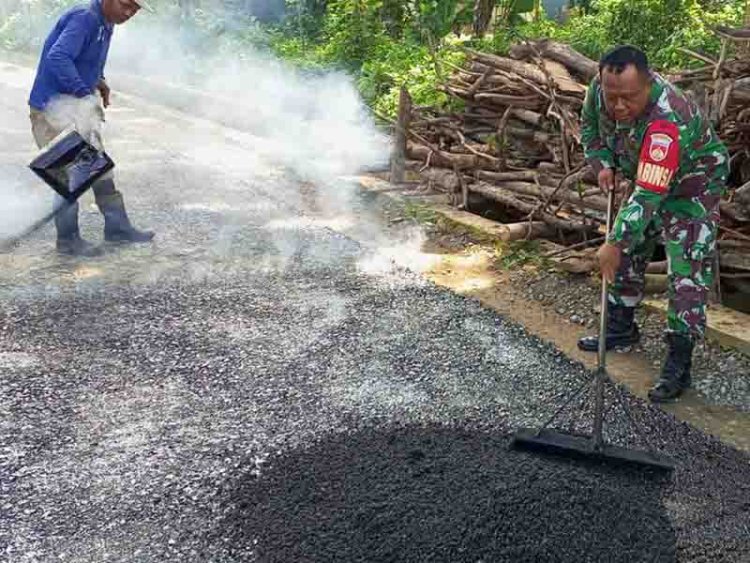 Berikan Semangat, Babinsa Membantu Pengaspalan Jalan di Permukiman Warga