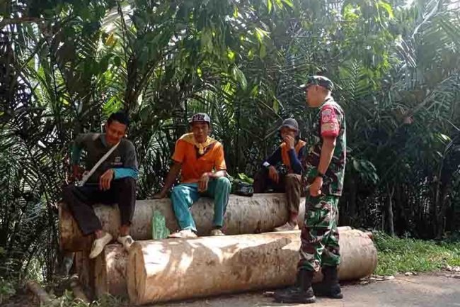 Babinsa Komsos dengan Bapak Asnan buruh pikul kayu