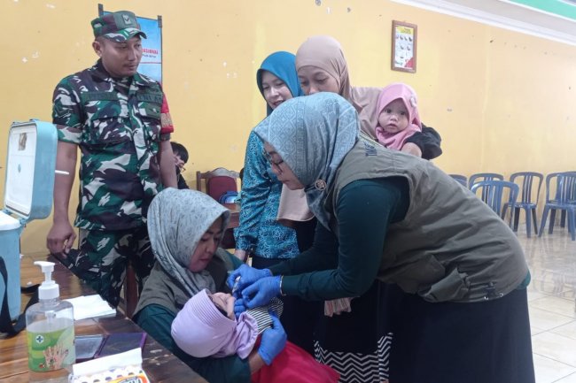 Babinsa Koramil 14/Madukara dampingi Tim Nakes berikan Imunisasi Pada Anak